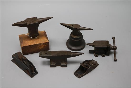 Three miniature anvils, two carpentry planes and a miniature vice tallest 11cm